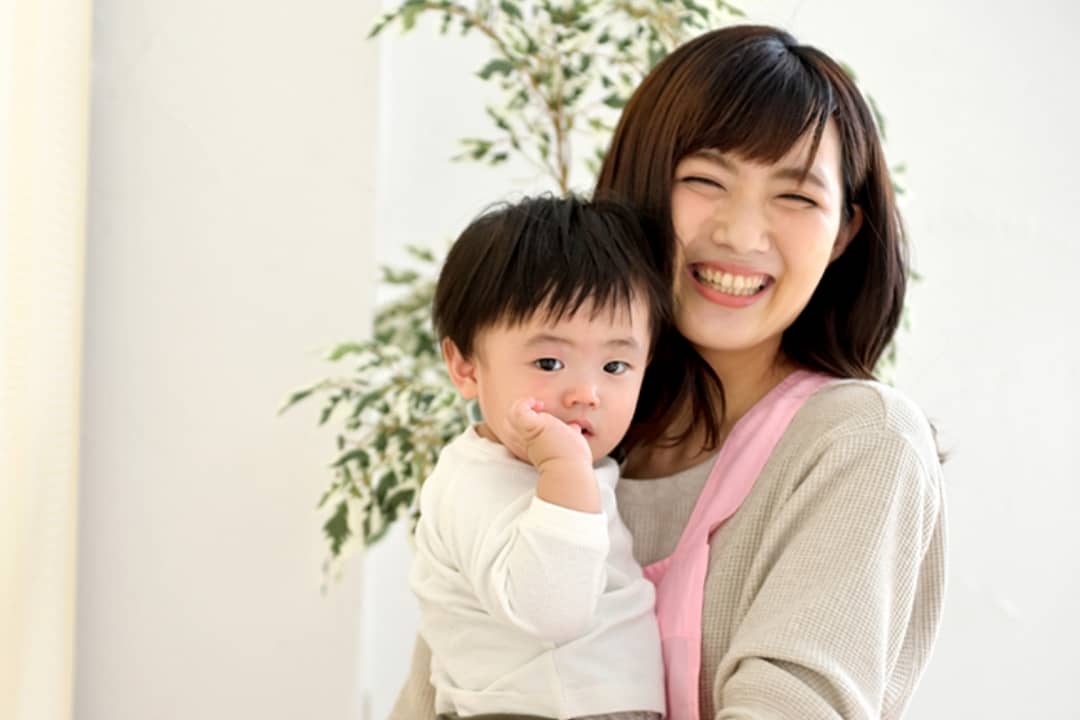 子どもを抱っこする看護師の写真